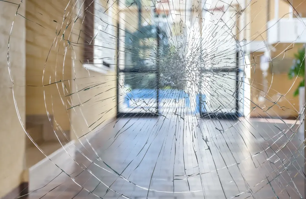Security film holding a shattered pane together in its frame